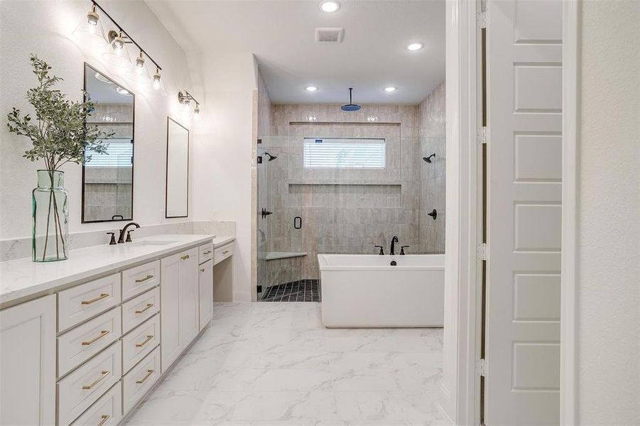 Bathroom featuring plus walk in shower, vanity, and tile patterned flooring