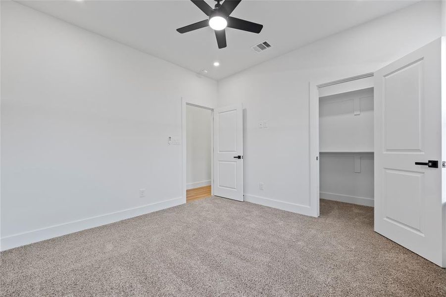 Unfurnished bedroom with ceiling fan, a closet, and carpet