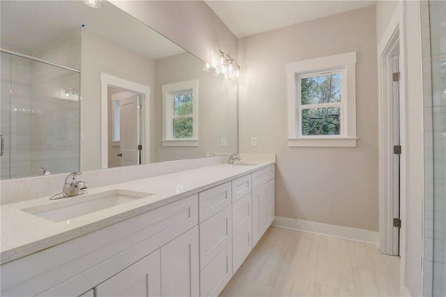 Bathroom with a wealth of natural light, tile flooring, and double sink vanity