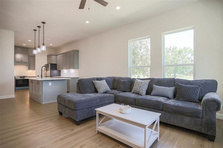 Living room featuring light hardwood / wood-style floors, sink, and ceiling fan