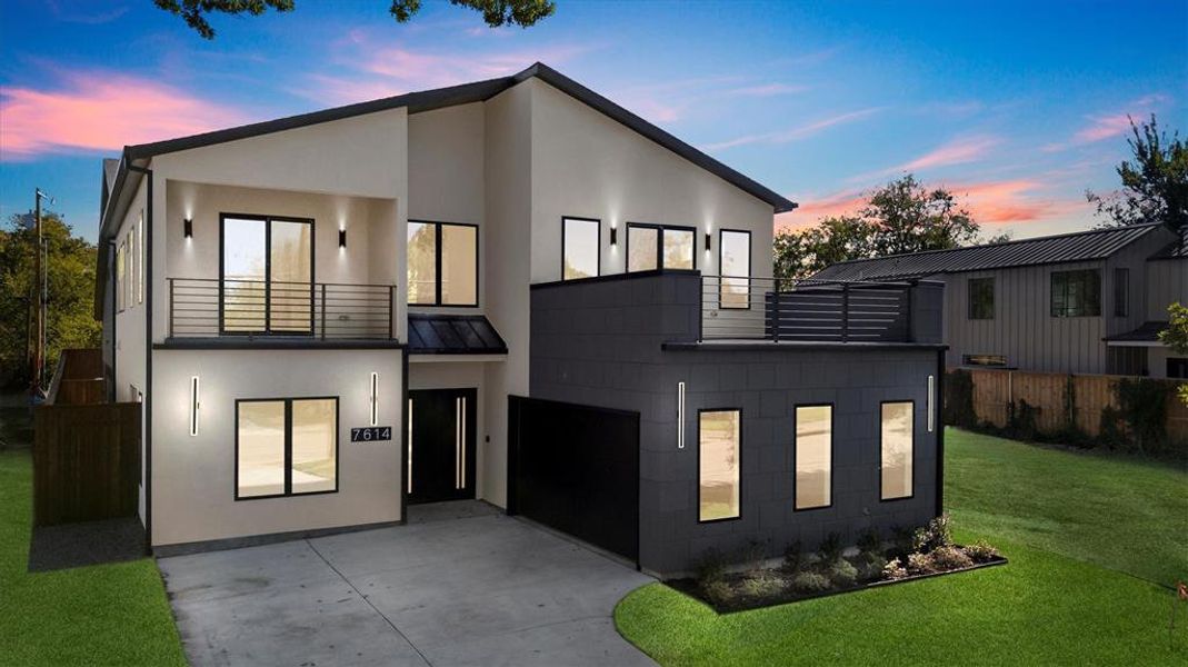 Contemporary house featuring a garage, a balcony, and a yard