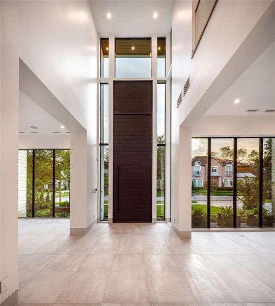 12' high Grand Foyer boasts a stunning presentation, a 14' steel front door and Porcelain floors seamlessly flow throughout most of the entire first floor