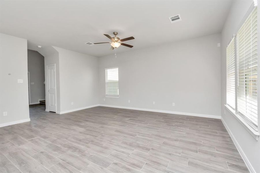 The heart of the home, this expansive living area offers a perfect blend of comfort and style. With large windows letting in natural light, durable tile flooring, and plenty of space for various seating arrangements, this room is ideal for both quiet nights at home and lively gatherings with friends and family. **This image is from another Saratoga Home with similar floor plan and finishes, not the June floorplan.**