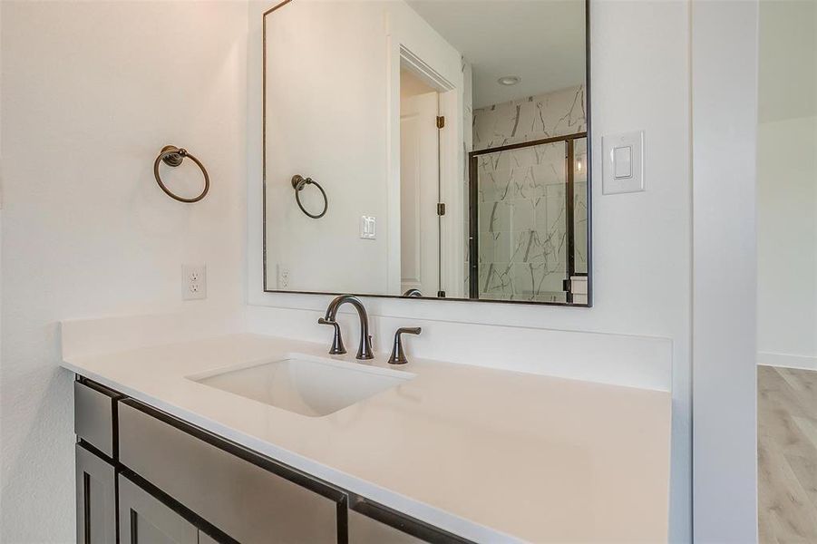 Bathroom with vanity, hardwood / wood-style floors, and an enclosed shower