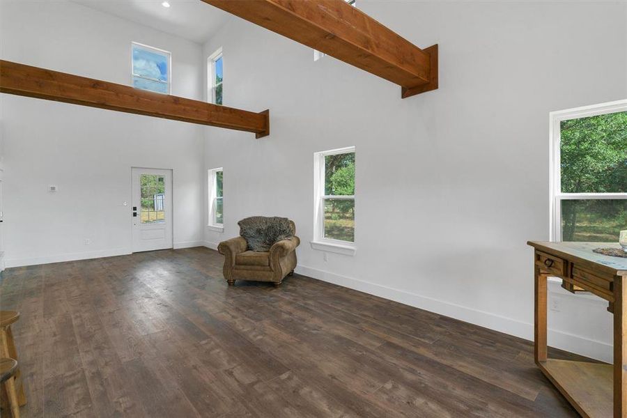 Unfurnished room with dark hardwood / wood-style floors and a high ceiling