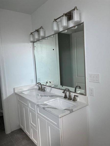 Bathroom with tile floors, large vanity, and double sink