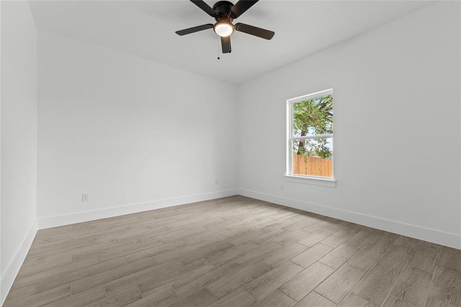 Empty room featuring light wood-type flooring and ceiling fan