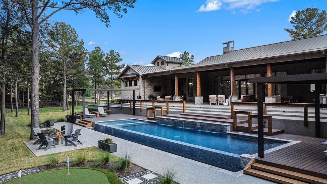 This backyard paradise showcases a sparkling pool and spa, a huge outdoor kitchen with fire pit, and a putting green!