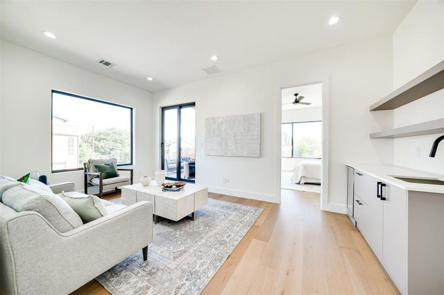 Living room featuring light hardwood / wood-style floors, sink, and ceiling fan