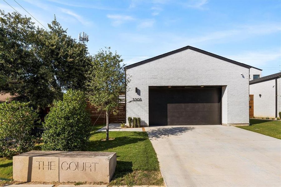 View of front of home with a garage and a front lawn