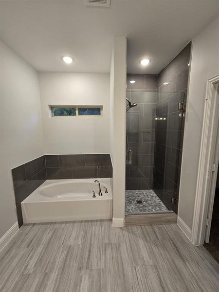 Bathroom featuring hardwood / wood-style floors and independent shower and bath