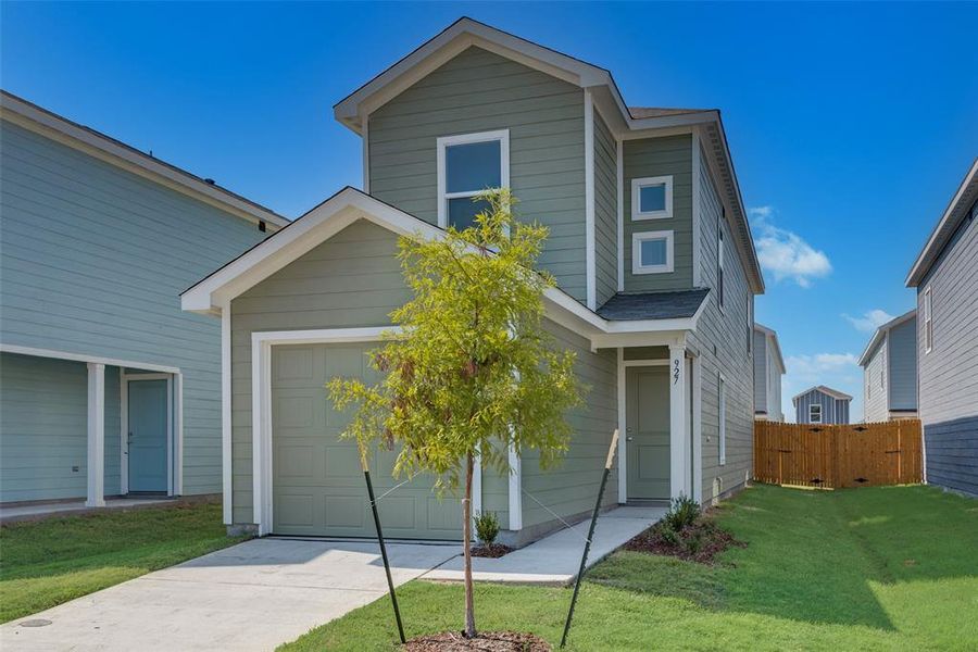 View of front of home with a front yard and a garage