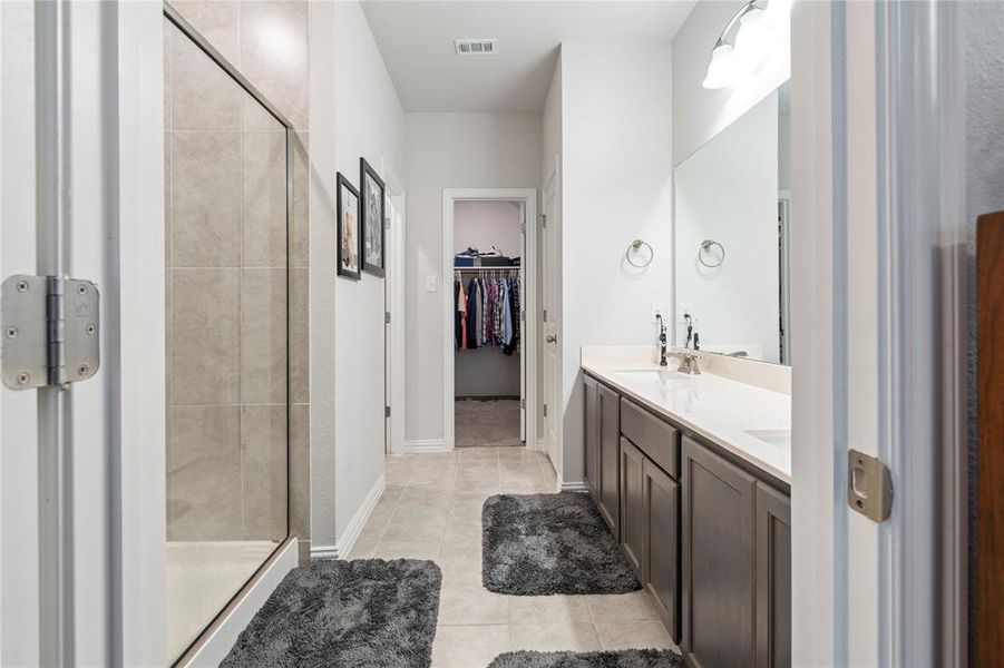 Bathroom with walk in shower, vanity, and tile patterned floors