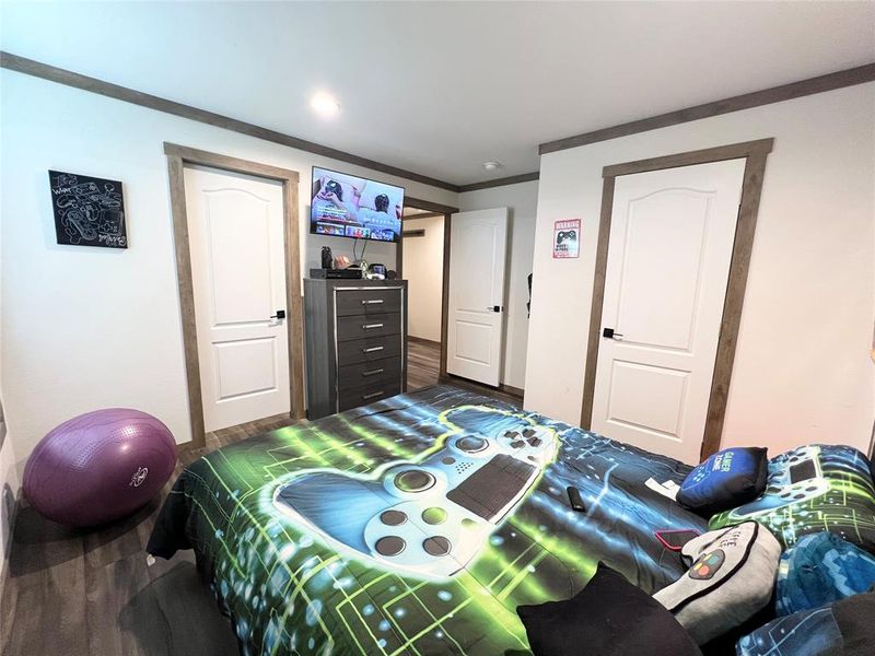 Bedroom featuring crown molding and dark hardwood / wood-style flooring