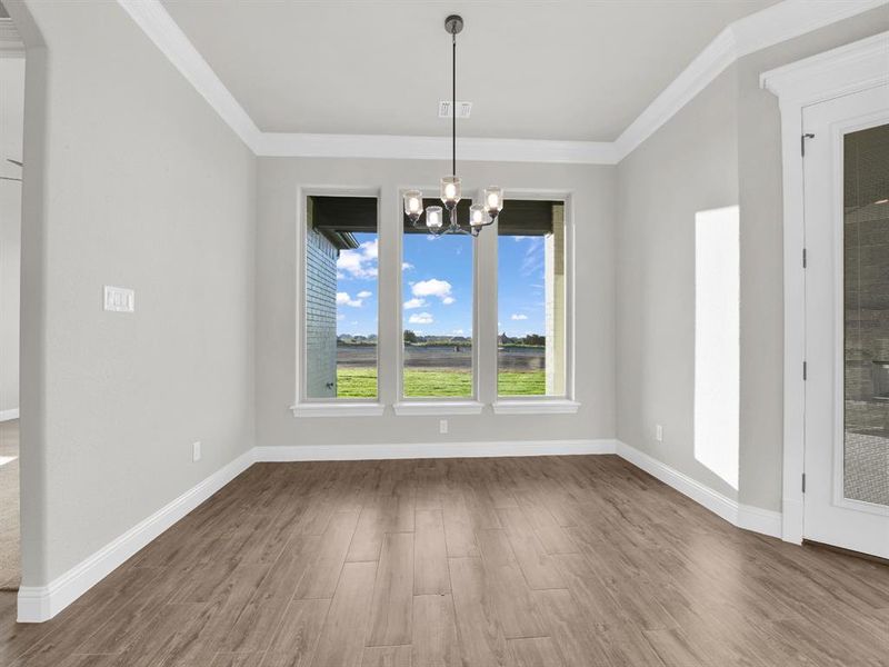 Unfurnished dining area featuring a chandelier, ornamental molding, and hardwood / wood-style floors