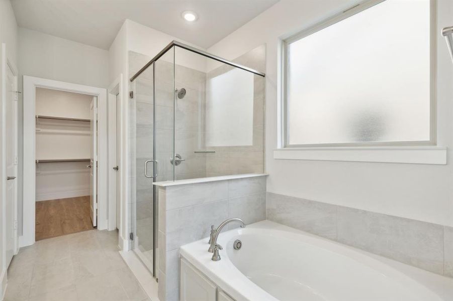 Bathroom featuring tile patterned floors and shower with separate bathtub