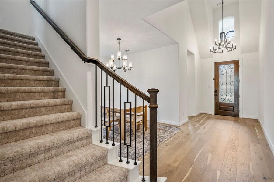 Returning to the front of the home, you see another view of the entry way and beautiful chandelier. You'll find the formal dining space, home office, and downstairs bedroom with ensuite bath.