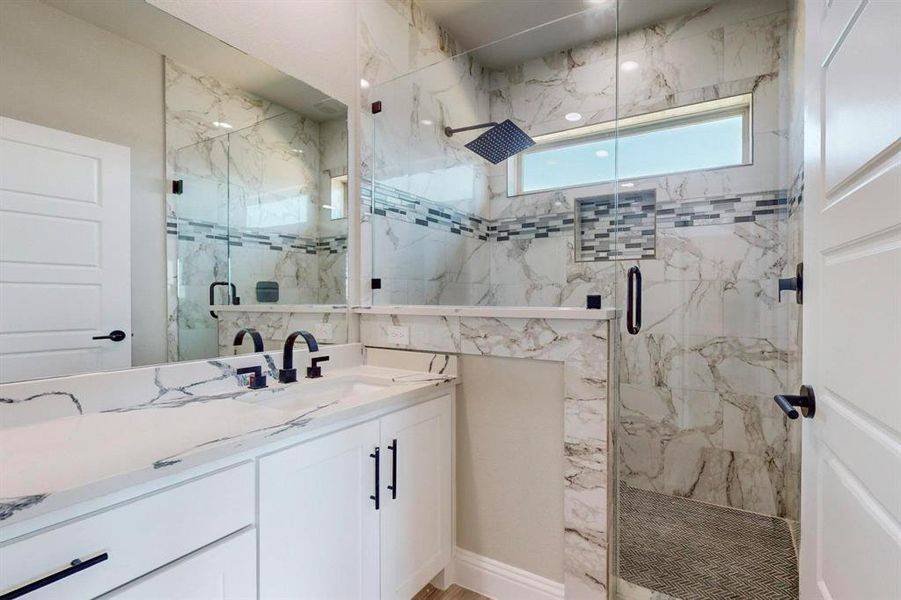 Bathroom featuring vanity and a shower with door