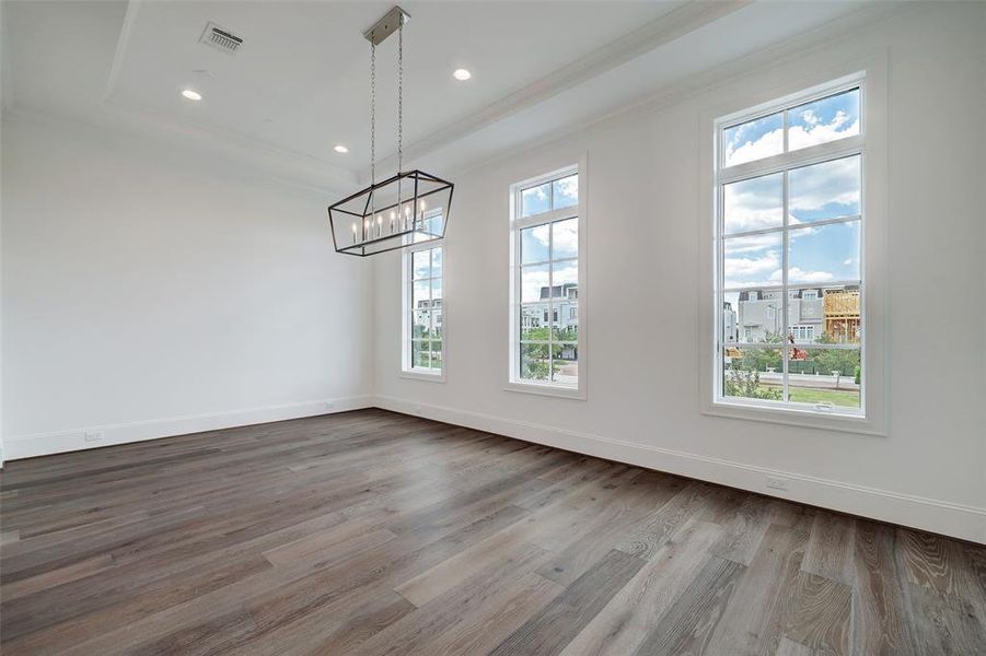 Dining room has great views of the subdivision & modern light fixture. Tons of natural light