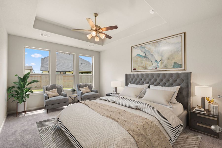 The primary bedroom is the perfect retreat within your home, featuring large windows and tray ceilings.