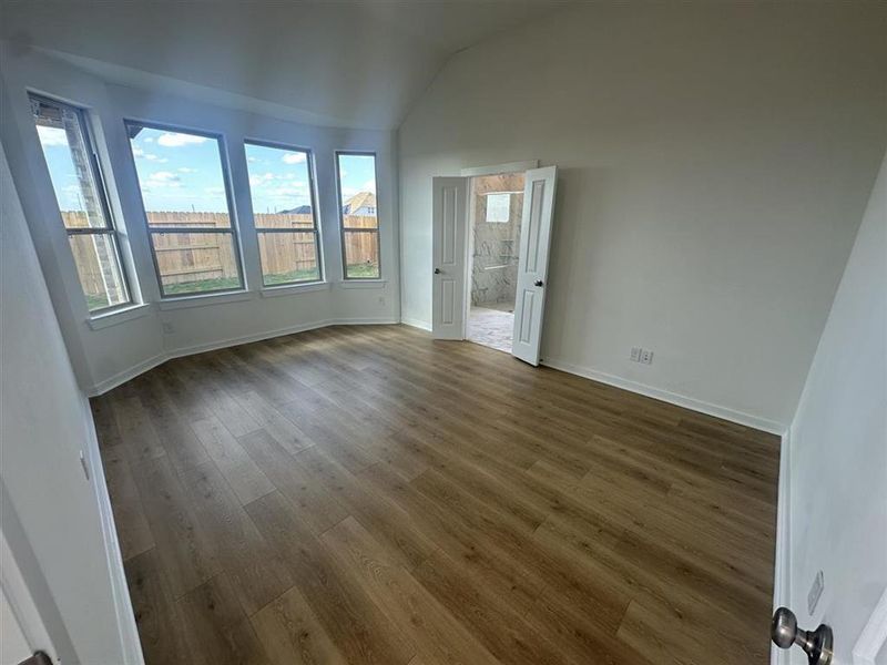 Primary bedroom has luxury vinyl plank flooring and bay window for extra room for seating area.