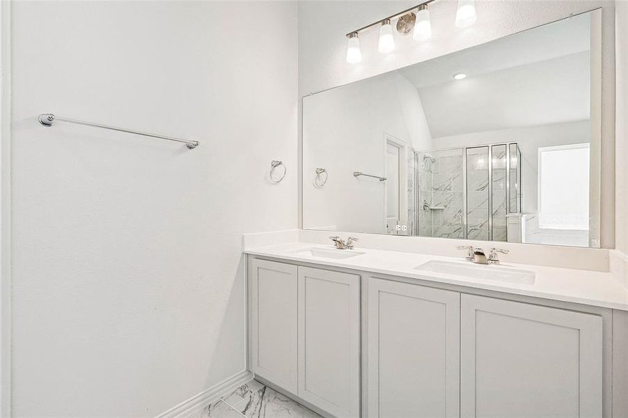 Bathroom with double vanity, an enclosed shower, tile patterned floors, and lofted ceiling