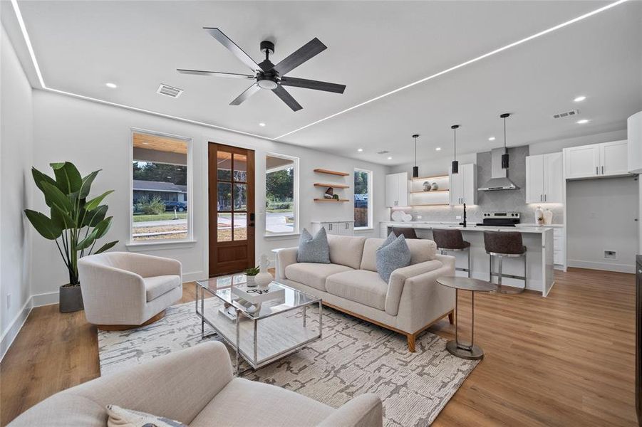 Living room featuring sink, light wood-type flooring, and ceiling fan