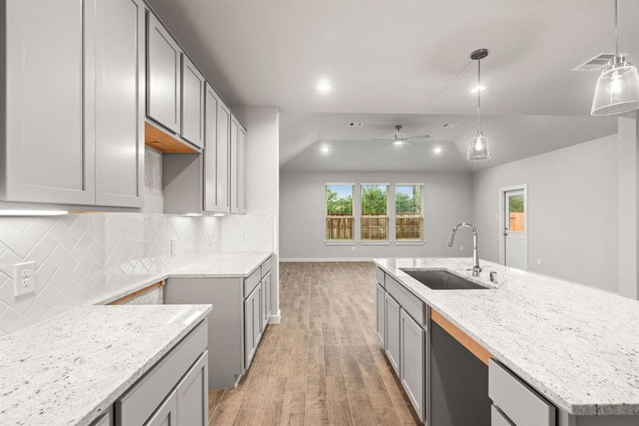 Discover another perspective of this stunning kitchen, generously appointed with an abundance of counter space. Sample photo of completed home with similar floor plan. As-built interior colors and selections may vary.