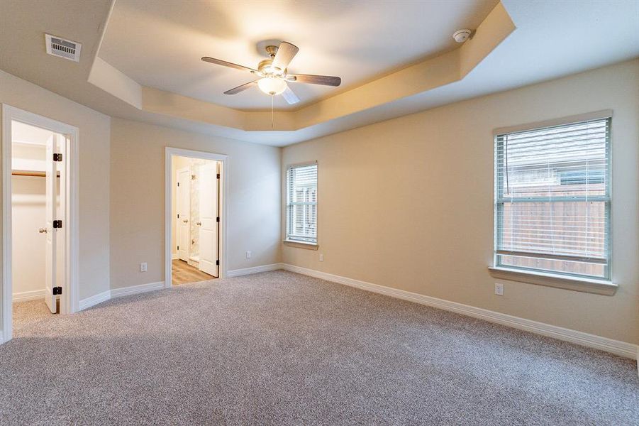 Beautiful - light and bright with light colored carpet, ceiling fan, window coverings and a tray ceiling