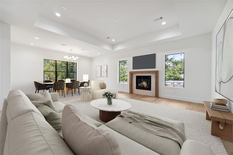 *Virtually rendered* The family room features a gaslog fireplace with a custom white oak mantle and Zellige tile surround. It also includes engineered white oak flooring, a tray ceiling, and designer neutral paint, all seamlessly opening to the formal dining room.