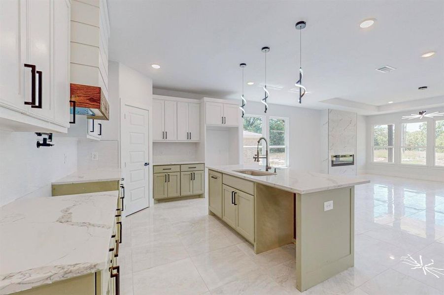 Kitchen with plenty of natural light, sink, and a kitchen island with sink