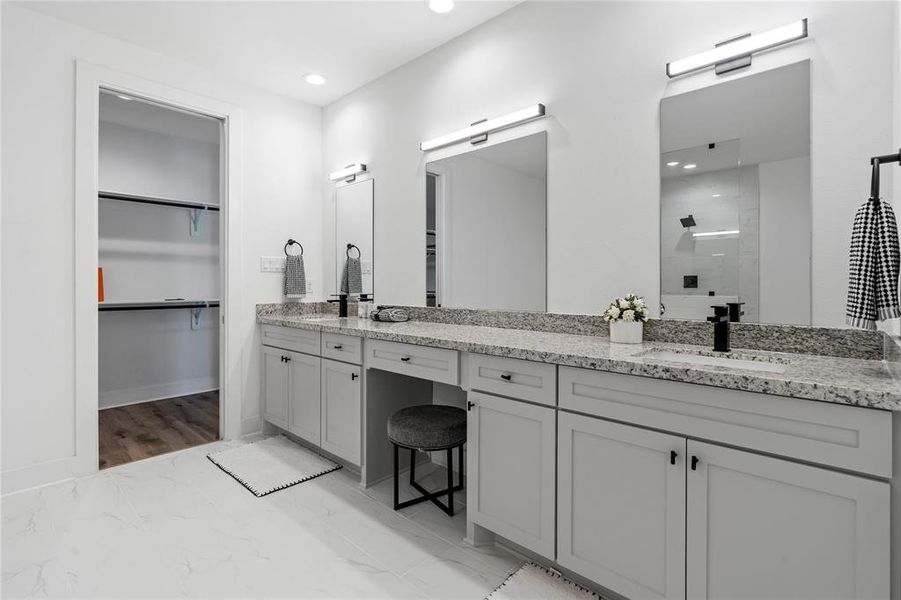 The primary bathroom’s dual sinks and oversized vanity seamlessly lead into the spacious walk-in closet