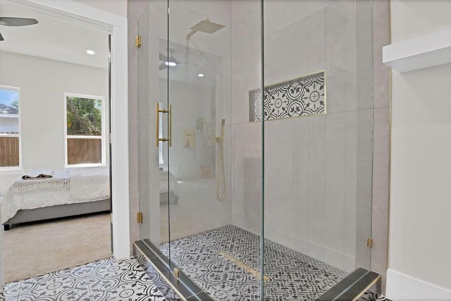 Bathroom featuring ceiling fan, a shower with door, and tile patterned floors