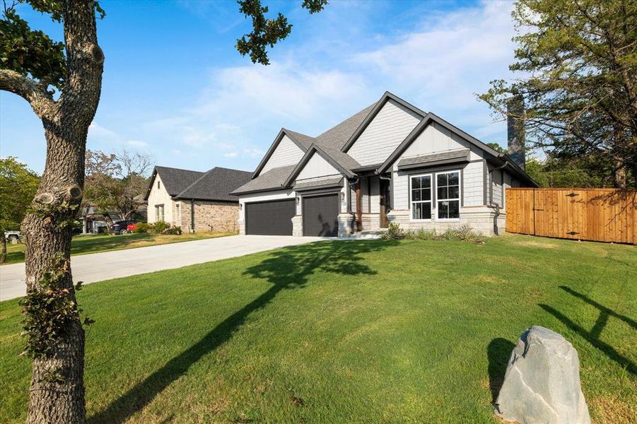 Craftsman inspired home featuring a garage and a front yard