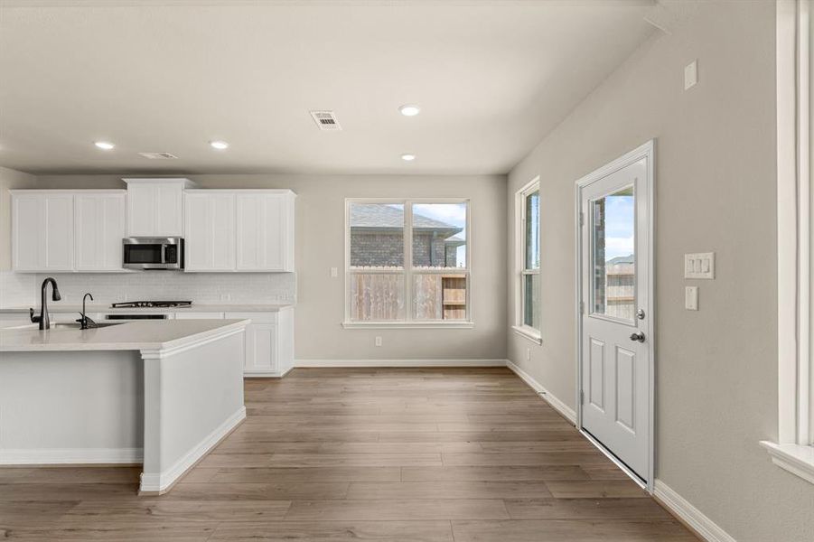 With an abundance of natural light streaming through the windows, the breakfast nook is bathed in a sunny glow, creating the perfect atmosphere to enjoy your morning coffee or a family breakfast.