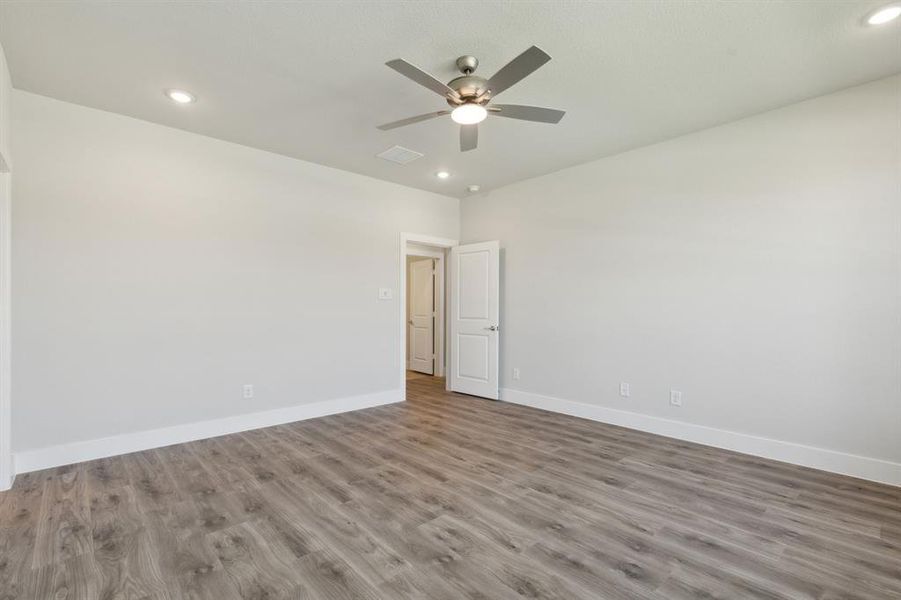 Unfurnished room with ceiling fan and hardwood / wood-style flooring