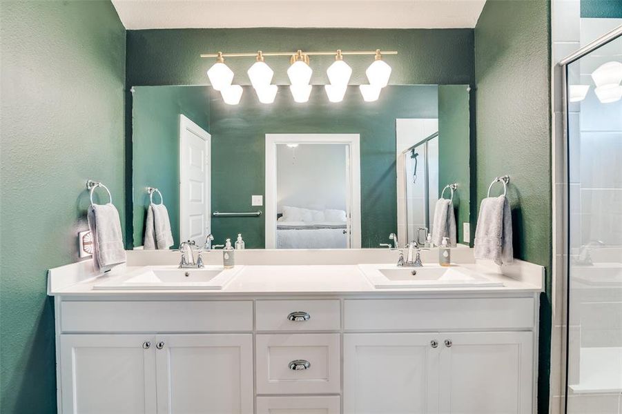 Bathroom featuring a shower with door and vanity