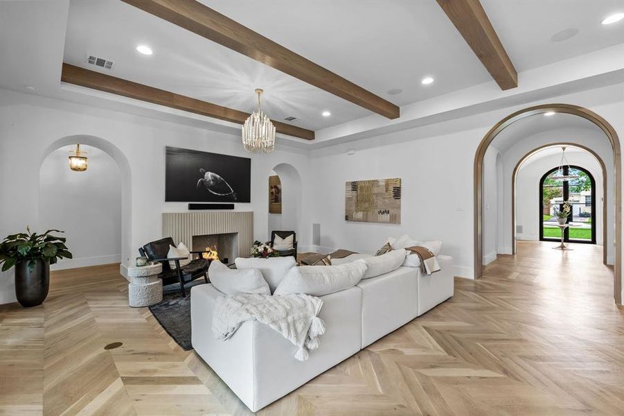 Living room with a notable chandelier and light parquet flooring