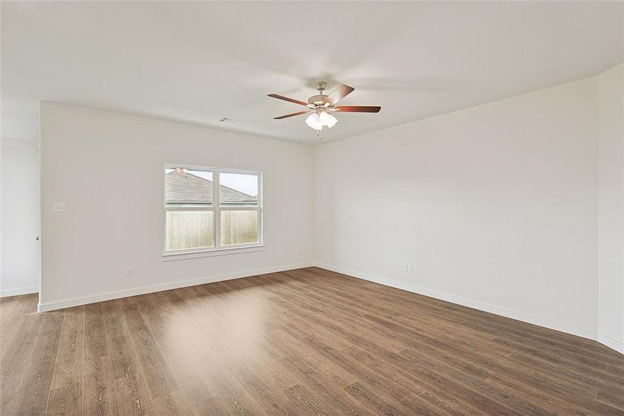 Spare room with dark wood-type flooring and ceiling fan