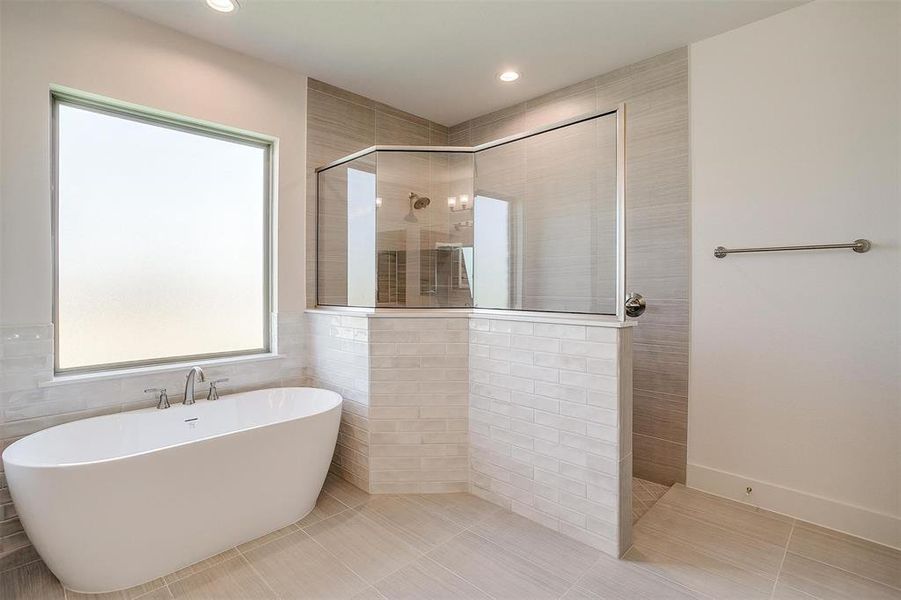 Bathroom with tile walls, tile floors, and a healthy amount of sunlight