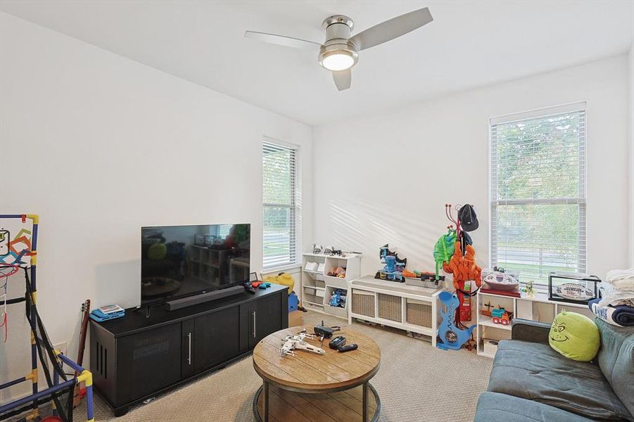 Living room with ceiling fan, carpet flooring, and plenty of natural light