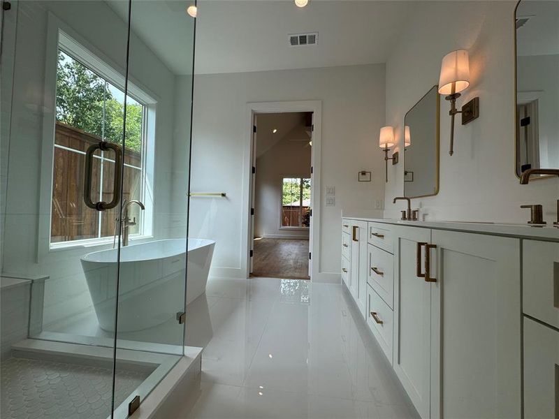 Bathroom featuring an enclosed shower, tile patterned flooring, and double sink vanity