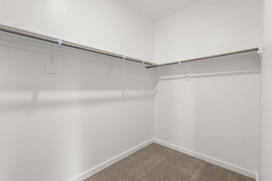 Walk in closet in the Prestigious Primary Suite offers an abundance of storage, hanging space and built-in shelving.