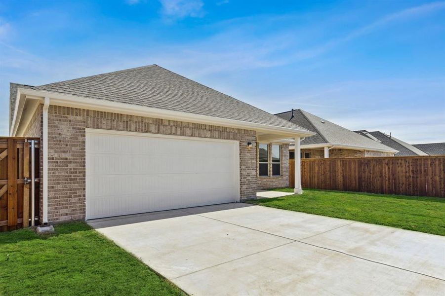 Single story home featuring a garage and a front lawn