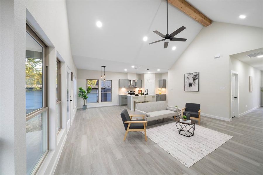 Living room featuring beam ceiling, high vaulted ceiling, light wood-type flooring, and ceiling fan