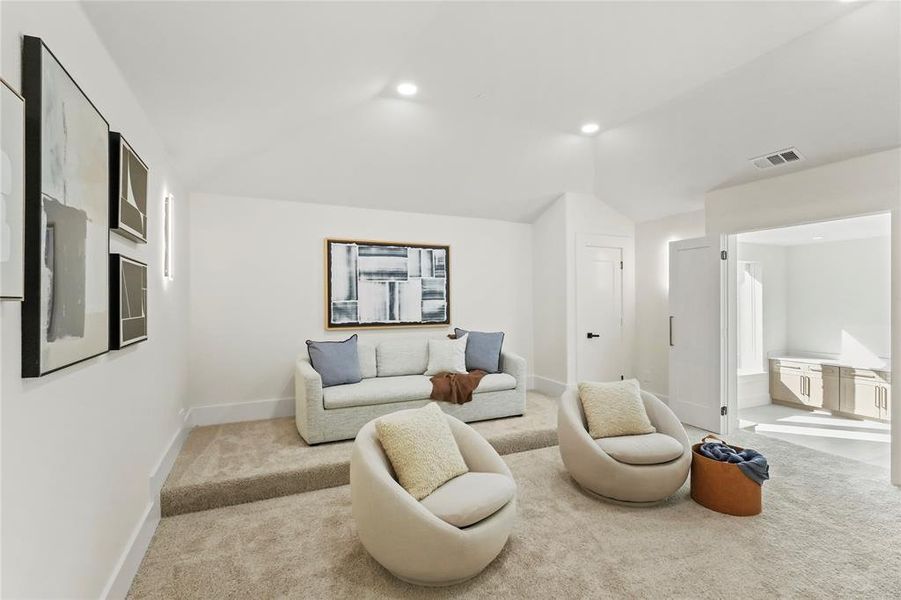 Carpeted living room featuring lofted ceiling