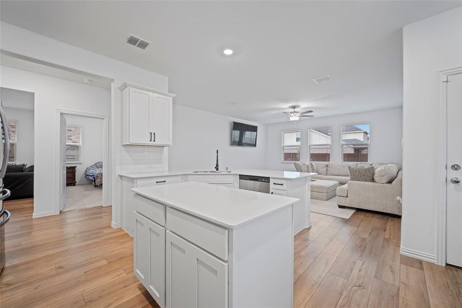 Kitchen with white cabinetry, light hardwood / wood-style flooring, and kitchen peninsula