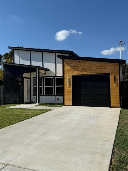 Modern Contemporary home featuring a front yard and a garage