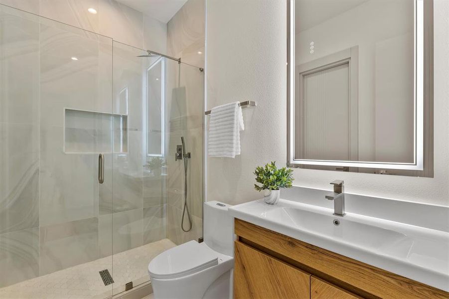 Bathroom featuring vanity, toilet, and an enclosed shower