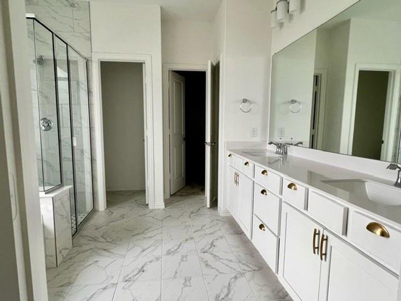Bathroom with a shower with shower door, tile flooring, and dual bowl vanity